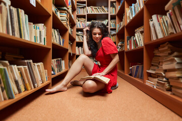 Back to school with attractive librarian in red dress - obrazy, fototapety, plakaty