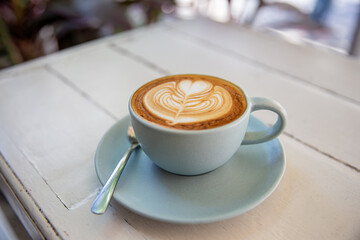 Blue cup of coffee on white rustic background with beautiful latte art