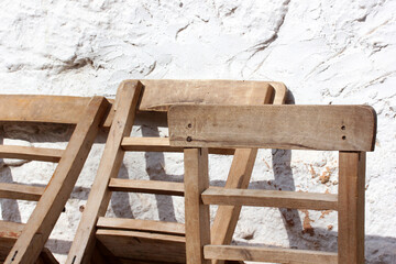 old fashioned wooden chairs in front of concrete wall