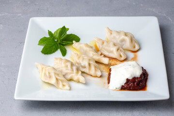 Traditional manti food on plate, top view. The concept of oriental cuisine. Uzbek food manty dumplings. (Turkish name; hinkel mantisi + cecen manti)