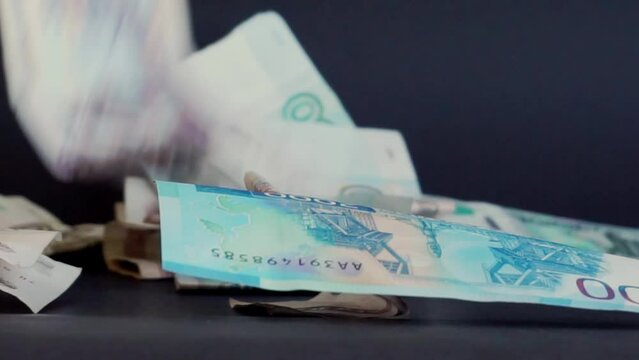 Paper banknotes of different denominations of the Russian ruble are falling on a black background in slow motion. Russian money. The national currency of the Russian Federation. Money exchange rate.