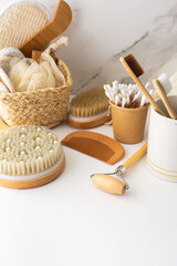 Wooden toothbrushes with natural bristles in a ceramic glass, face and skin care products, bath accessories, spa and beauty concept