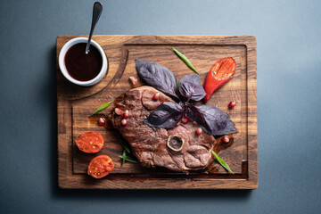 fresh lamb steak meat with berry sauce, tomato, rosemary, basil, pomegranate