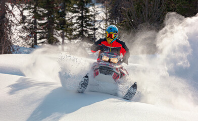 Snowmobile riding with fun in deep snow powder during backcountry tour. Extreme sport adventure,...