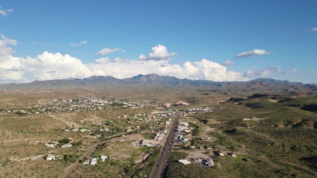4K Drone flyover highway in Kingman Arizona, light traffic with mountains in the background, large clouds behind the Hualapai mountains
