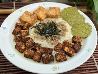 Congee with fried tempeh and stir pork and fried tofu