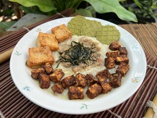 Congee with fried tempeh and stir pork and fried tofu