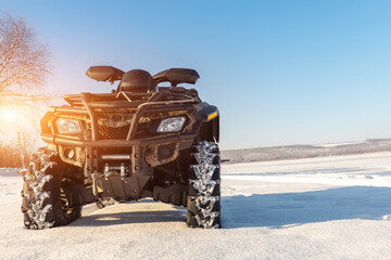 Front POV close-up detail view of quad bike offroad vehicle parked in snowdrift track on sunny snowy cold winter morning against clear blue sky. ATV adventure extreme sport. Nature country tour drive © Kirill Gorlov