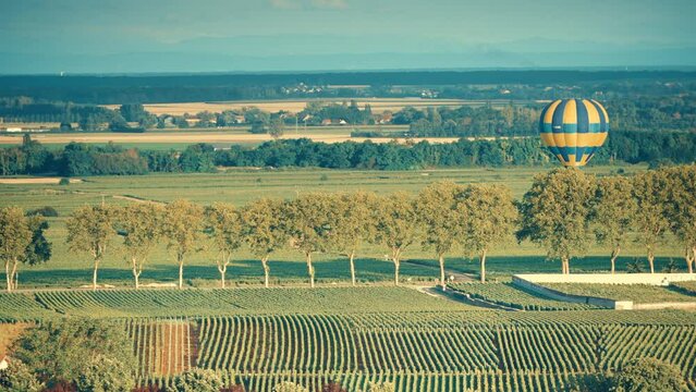 Pommard, Burgundy, France - August 8, 2021: Hot air balloon F- HCBB Ultramagic ride above the Burgundy landscape. Cote de Beaune, Pommard region.