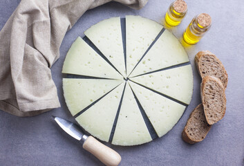 Aperitivo de queso cortado en lonchas sobre un plato de piedra circular
