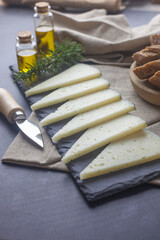 Queso manchego cortado en lonchas y colocado en un plato para hacer una presentación