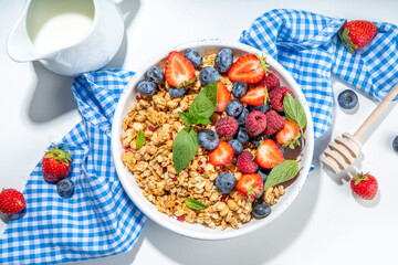 Healthy breakfast granola with fresh berry - strawberry, raspberry, blueberry on white background