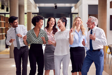 Portrait Of Smiling Multi-Cultural Business Team Having Fun And Laughing Inside Office Building