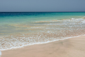 Fototapeta na wymiar Summer beach, ocean waves on a tropical sea with deep blue wawes.