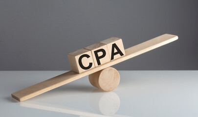 CPA on wooden cubes on a wooden balance , business concept