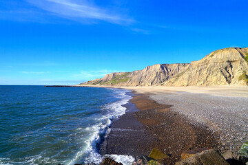 Klippe und leerer Strand bei Ferring an der Nordseeküste Dänemarks in perfektem Abendlicht vor blauem Himmel mit einigen Wolken am Horizont, Urlaub, Idylle, Freiheit, Reisen