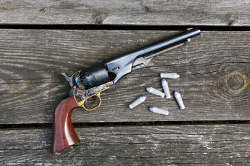 Black powder revolver and cartridges on an old board - obrazy, fototapety, plakaty