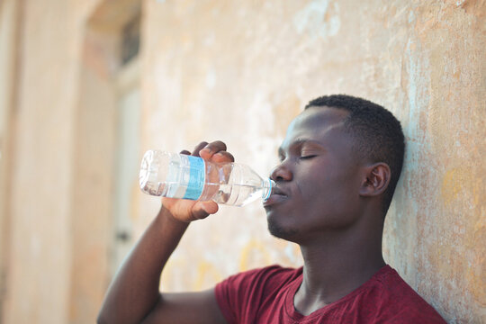 young man drinks water from a bottle