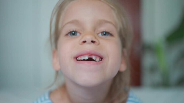Happy child smiles with his teeth at camera. Cute little girl in bright room alone with beautiful toothless smile. child is losing her milk teeth. Happy child smile at the camera.