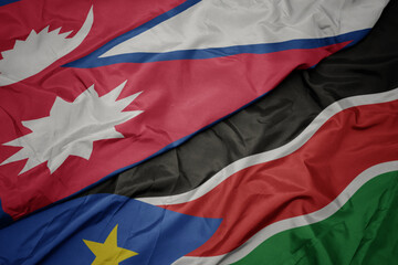 waving colorful flag of south sudan and national flag of nepal.