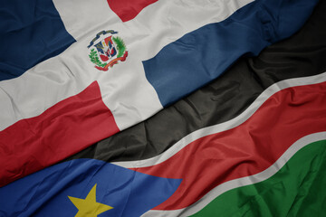 waving colorful flag of south sudan and national flag of dominican republic.