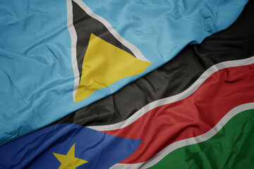 waving colorful flag of south sudan and national flag of saint lucia.