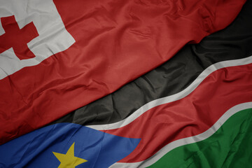 Fototapeta premium waving colorful flag of south sudan and national flag of Tonga .