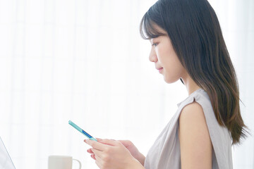 リビングでスマホを使う女性