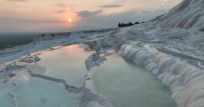 Pamukkale Travertines Cinematic Aerial Drone footage. Turkish famous white thermal bath with healthy clean water in a beautiful sunset. 