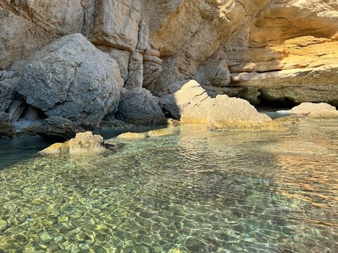 Pebble secluded beach with clear sea water and scenic coastal rocks. Paradise pristine nature in Montenegro.