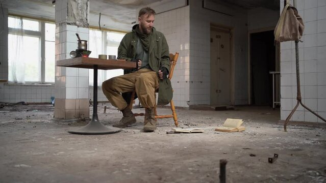 Post apocalyptic survivor drink hot water in a ruined building. Nuclear apocalypse survivor. Environmental disaster, armageddon