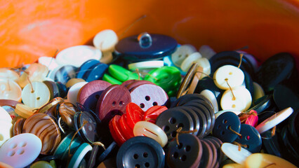Multi-colored buttons in a box in a variety of sizes from small to very large