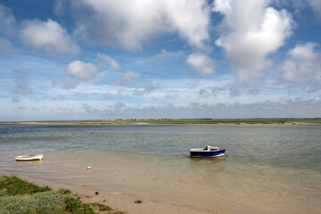 Obraz premium Little blue boat on the Bay of Somme on a cloudy spring afternoon, Hauts-de-France, France