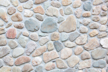 Texture grunge background old wall made of multicolored stones sealed with cement light color wallpaper modern interior exterior room backdrop design can be used as model building, house wall. 