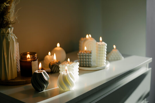 Home interior decor. White dresser with dried flowers in vase and candles. Still life, hygge concept