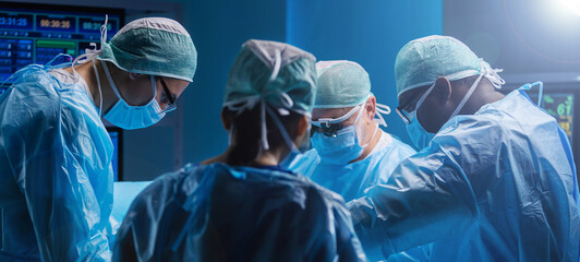 Diverse team of professional medical surgeons perform surgery in the operating room using high-tech...