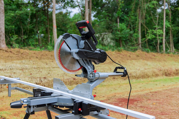 Circular miter saw on saw stand with under construction a newly constructed house