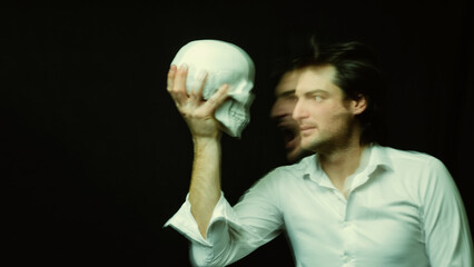 portrait of psychopathic man with mental disorders with a human skull in his hand