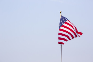 American Flag on flag pole with blue sky