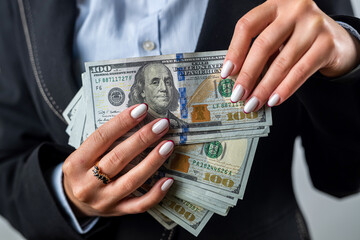 young girl holds a large sum of dollars in her hands and counts money in a black purse.