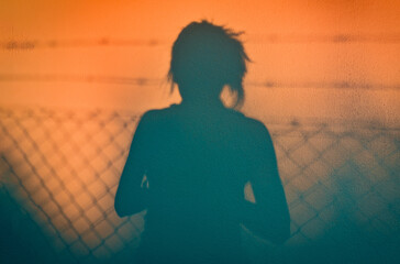 The shadow of a girl on the wall in the light of the sunset. Evening