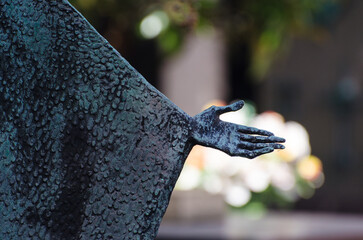 Il dettaglio della mano di una statua bronzea  su una tomba del cimitero maggiore di Milano