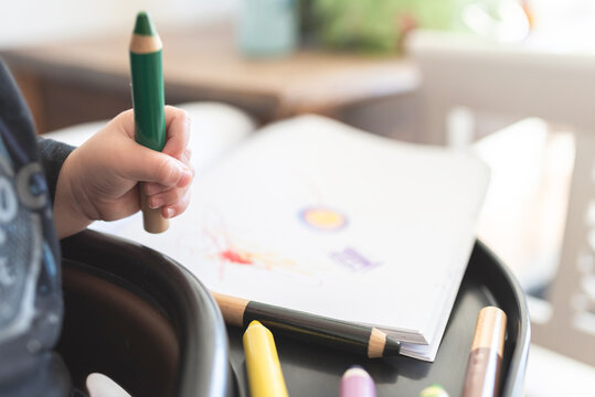 close-up view of toddler using crayons to draw a picture