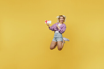 Full body young excited blonde woman 20s she wear pink tied shirt white t-shirt jump high hold...