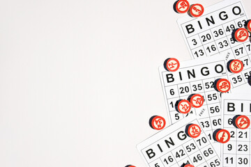 Many wooden chips with numbers and cards for a board game of bingo or lotto on a light background.