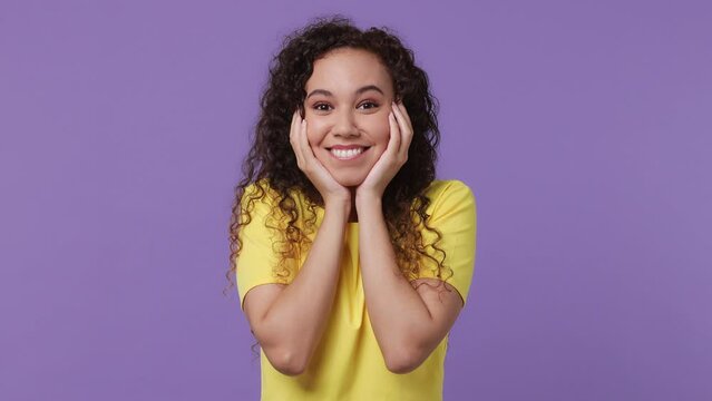 Young fun woman of African American ethnicity 20s she wear yellow t-shirt look shocked surprised wow showing hands brain explosion head isolated on plain pastel light purple background studio portrait