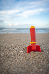 Fototapeta na wymiar 砂浜とおもちゃのシャベル　コピースペース