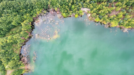 Blue lakes from above. Lakes in green forest in evening sunlight aerial drone view. Scenic summer background. Picturesque lakeside with forest. High quality photo. High quality photo