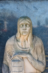 La statua di marmo di una donna dolente su una tomba del cimitero maggiore di Milano