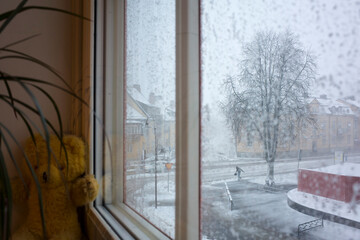 Snowstorm in Sweden, Strong wind city street view through snow covered window, Vasteras, Winter nasty weather in Scandinavia